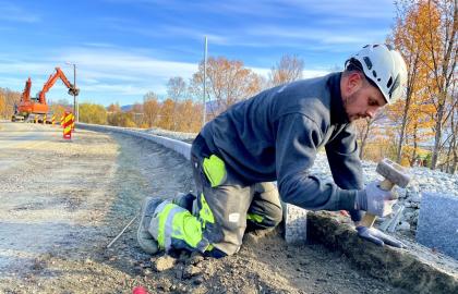 Vegarbeid og arbeider som legger stein ved utbedring av skolevei på Kvaløya
