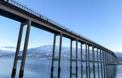 Tromsøbrua med gående i gangfeltet på sørlig side