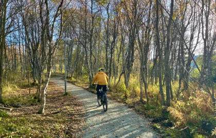 Mann som sykler på grusvei