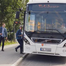 Buss som stopper ved holdeplass i sentrum og slipper på passasjerer.